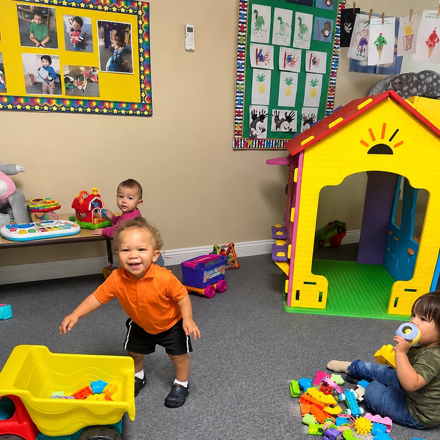 A toddler playing with a toy dump truck in the classroom