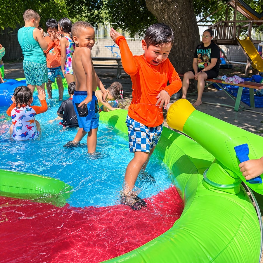 Children playing in an inflatable splash pool on a sunny day