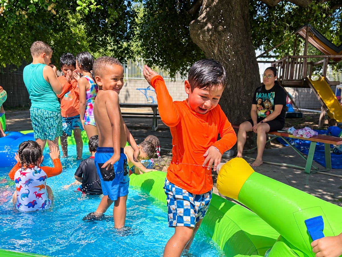 Children playing in an inflatable splash pool on a sunny day