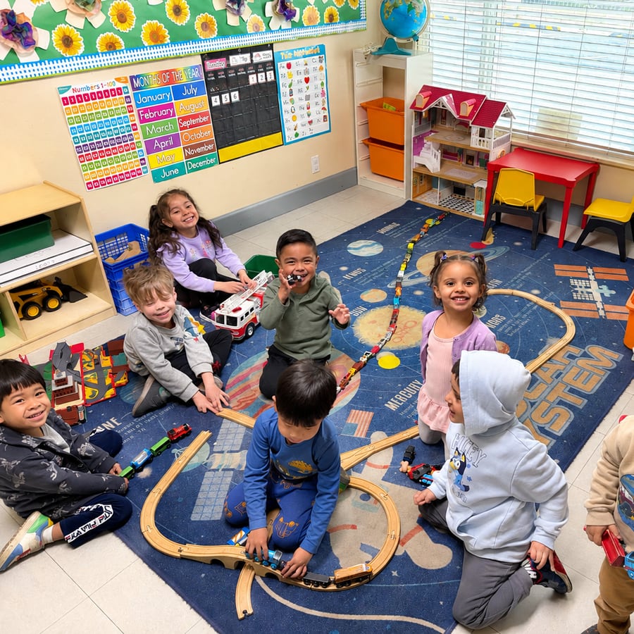 A group of children playing with a wooden train set on a classroom rug