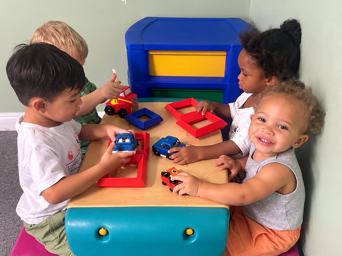 Children playing together with toys at a low table in the classroom