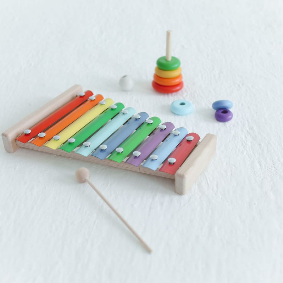 A colorful toy xylophone and mallet, representative of music class instruments